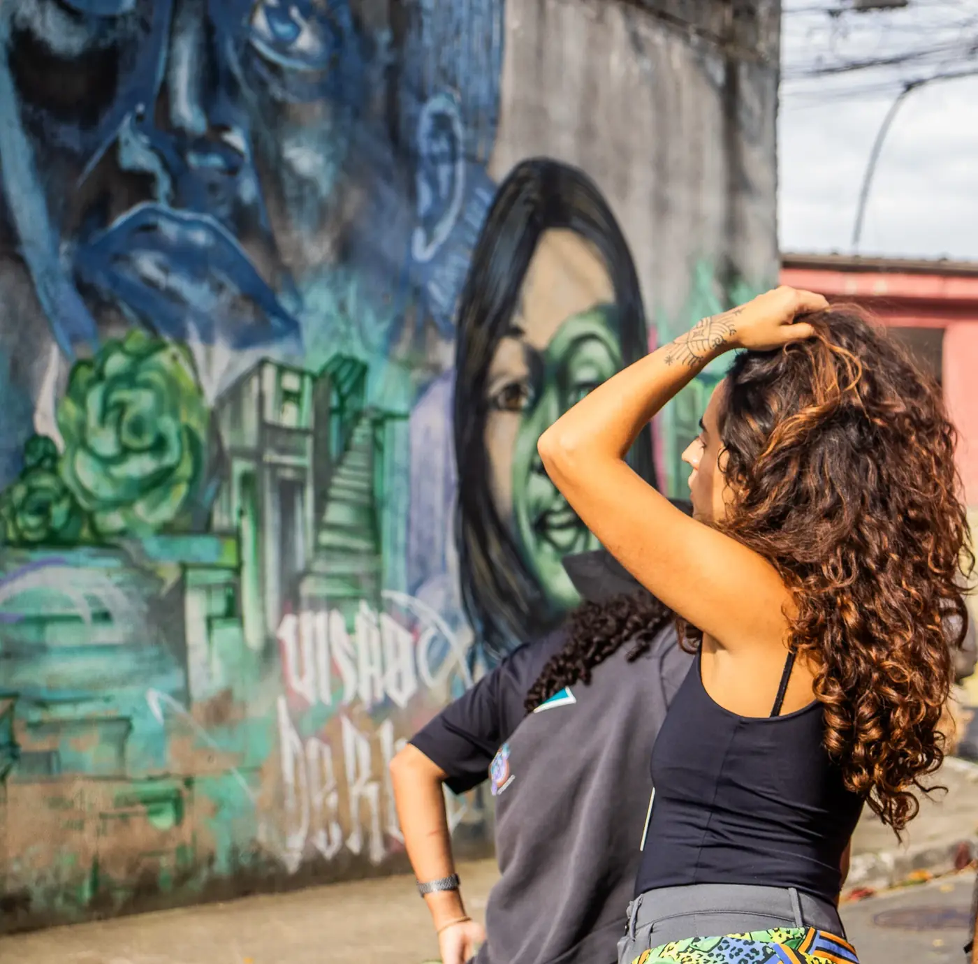 Uma visitante observa um mural com rostos pintados na Vila Flávia.