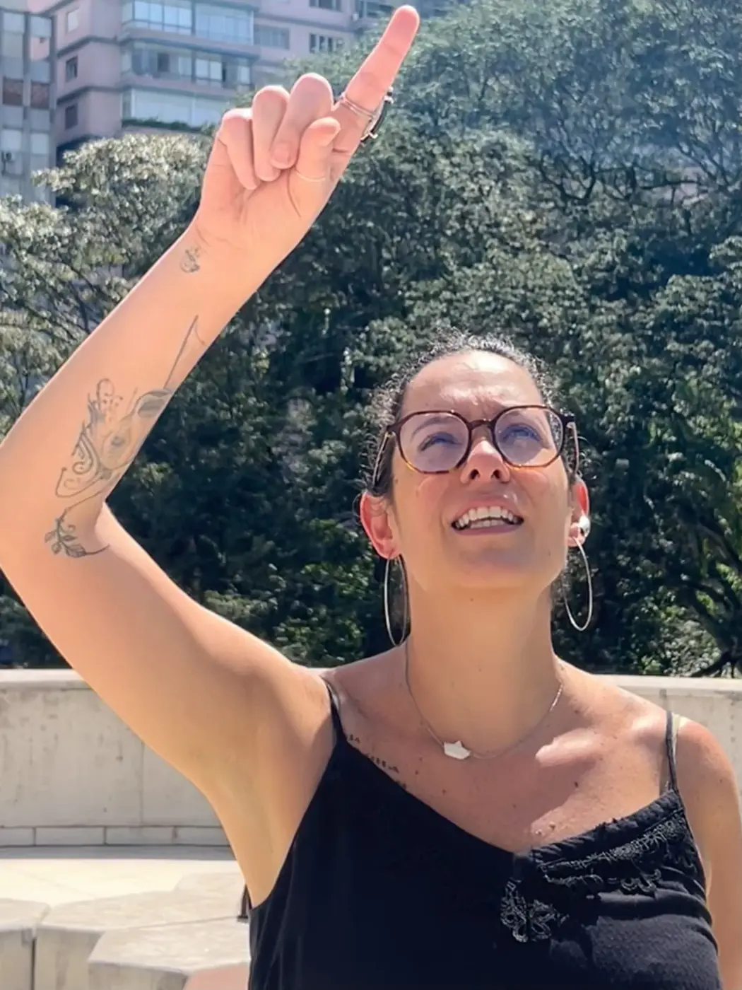 Mirella Lucchesi ao ar livre, com o braço erguido.