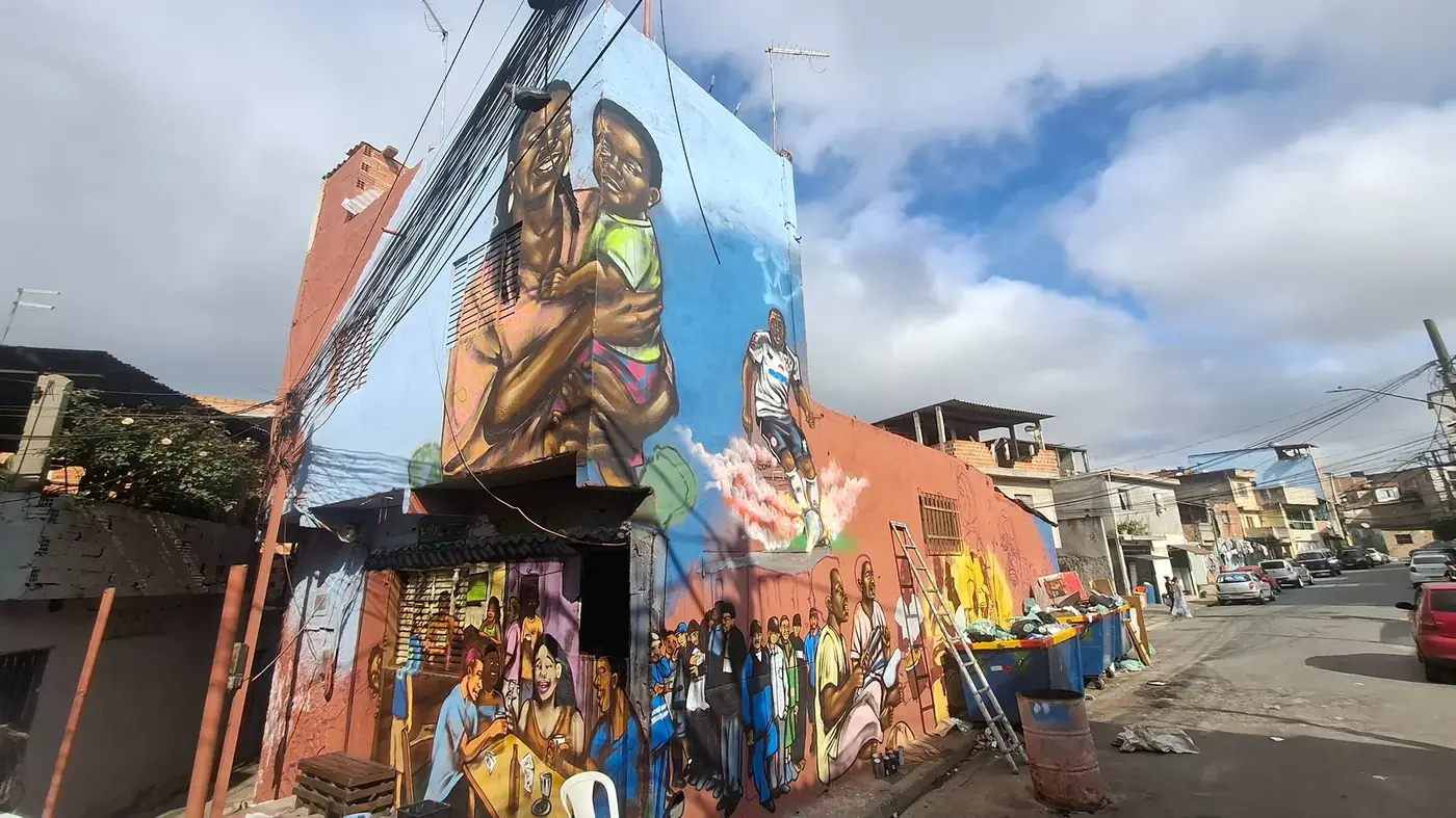 Panorama de uma esquina da Vila Flávia com grafites monumentais nas paredes das casas.